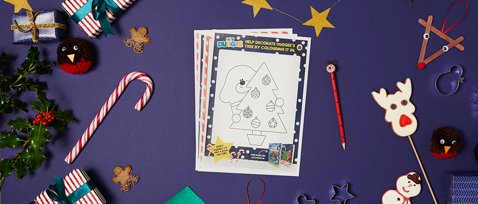 A photo of the Hey Duggee Christmas colouring sheets on a dark purple background surrounded by Christmas decorations