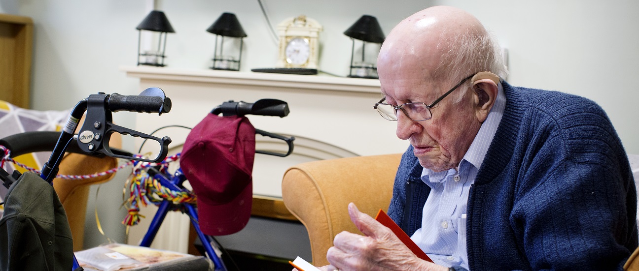 An elderly man reading a book
