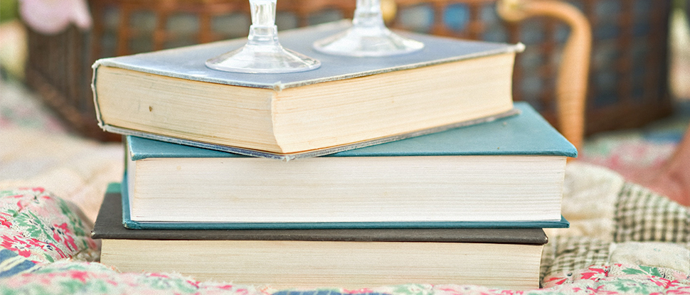 image of three stacked books on a picnic blanket