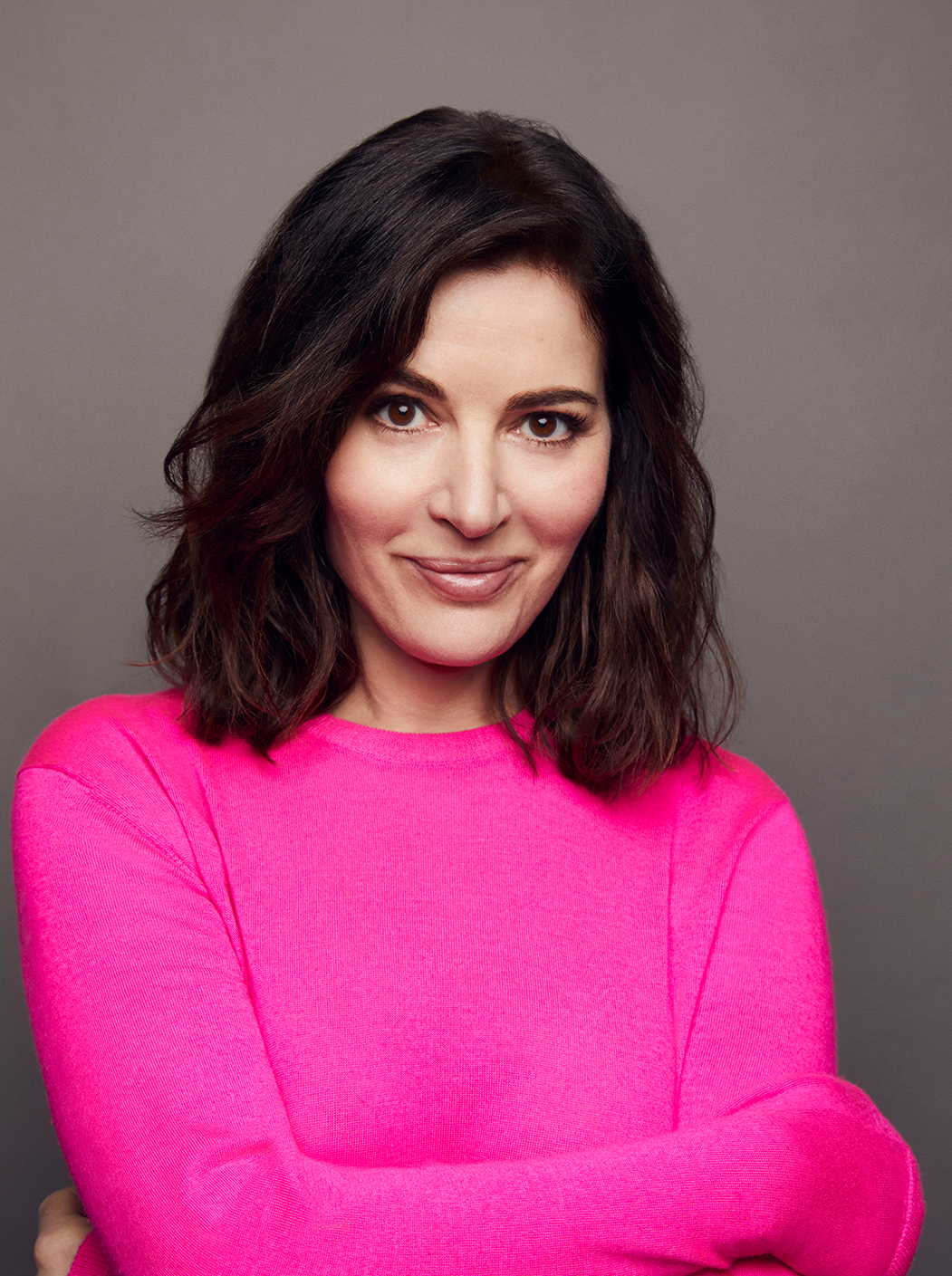 Photograph of Nigella Lawson in a bright pink top, facing the camera and smiling.