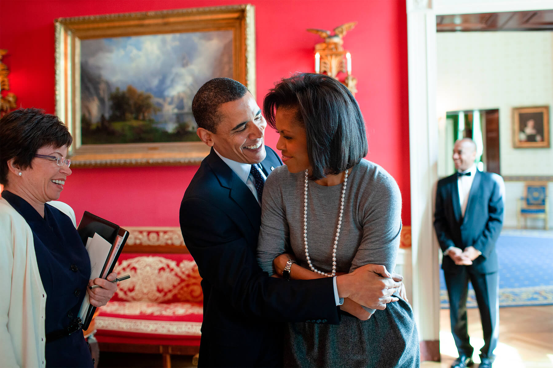 President Barack Obama hugs First Lady Michelle Obama in the Red Room of the White House, with senior advisor Valerie Jarrett, March 20th 2009.