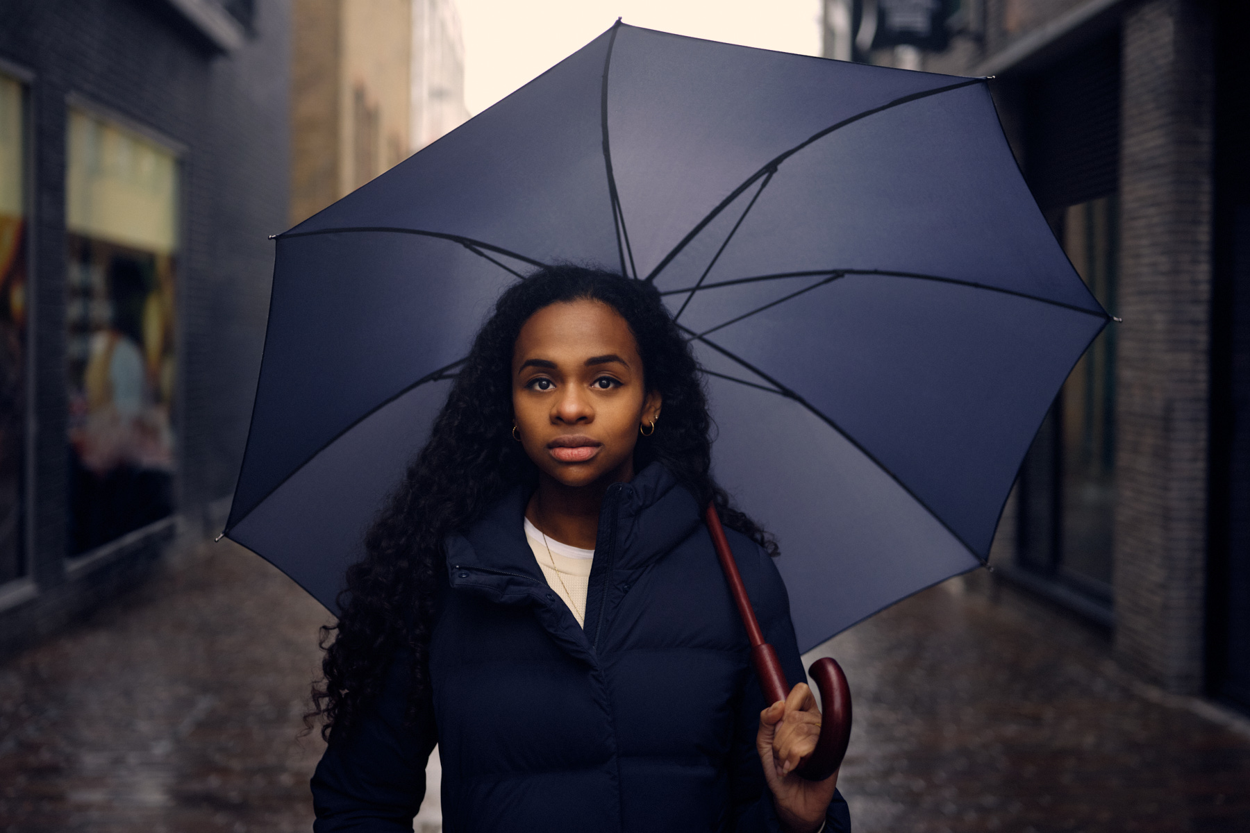 A photograph of Hafsa Zayyan under an umbrella