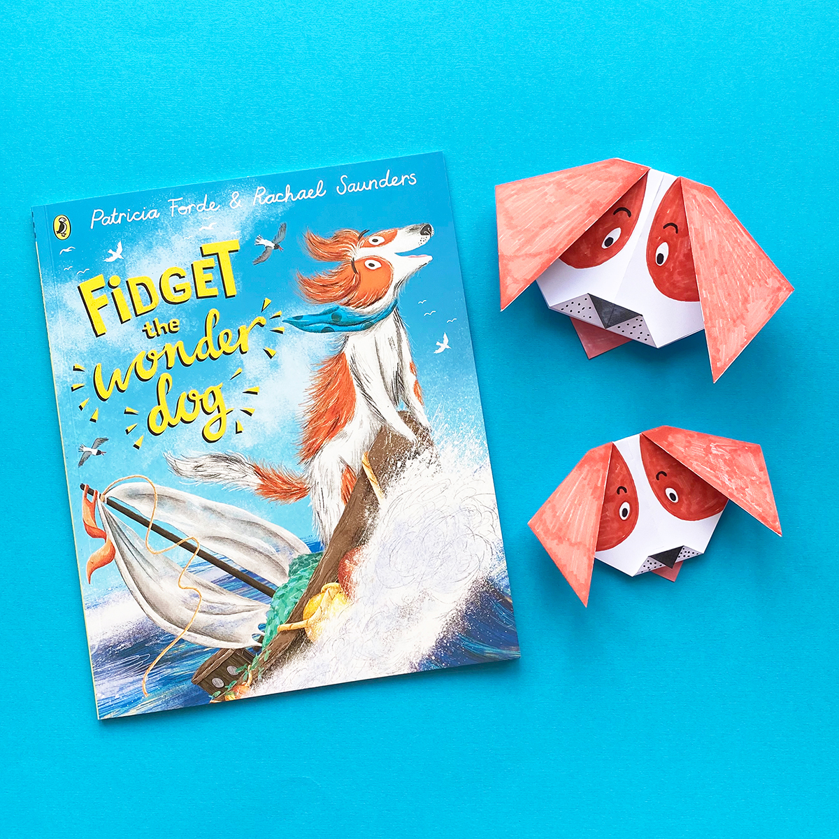 Photo of the book Fidget the Wonder Dog with two origami dogs on a blue background