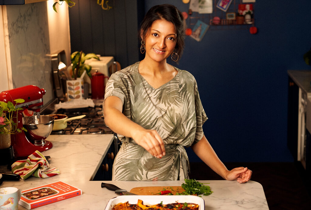 A photo of author Rukmini Iyer in her bright kitchen