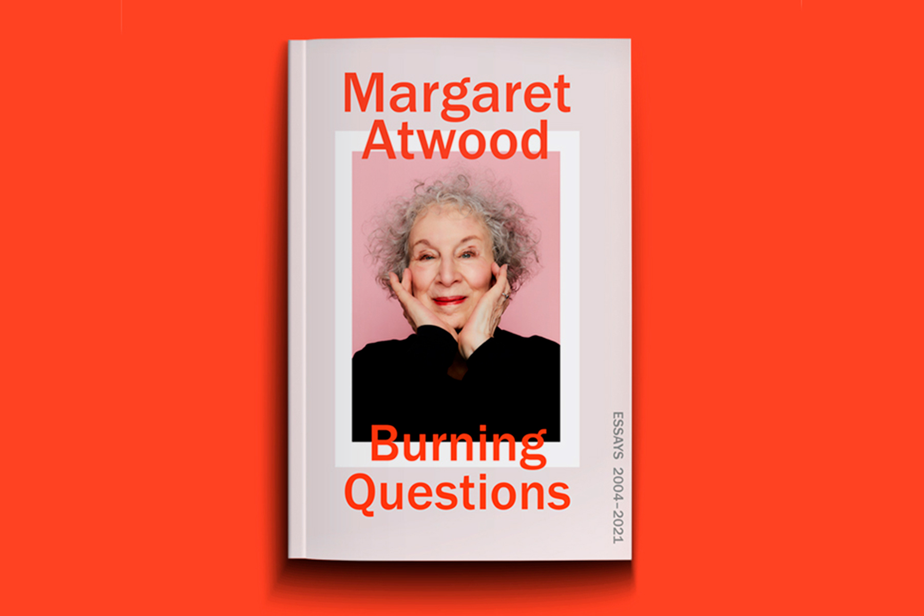 A photograph of Margaret Atwood's forthcoming book, Burning Questions, on a red background