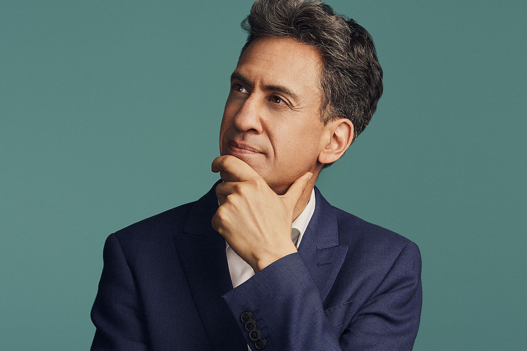 A portrait of Ed Miliband against a green background