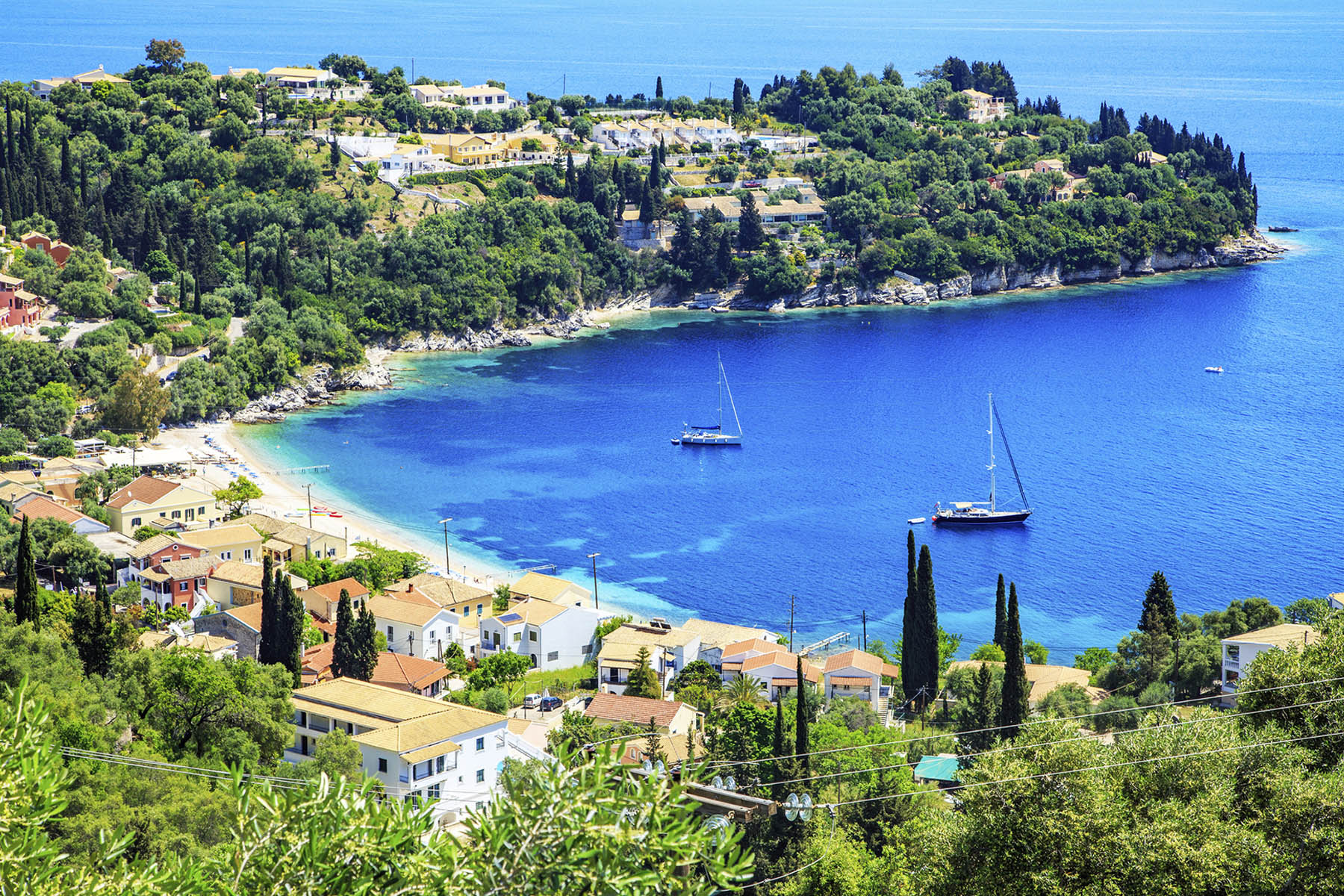 A photo of a beach on the Greek island of Corfu with stunning blue waters.