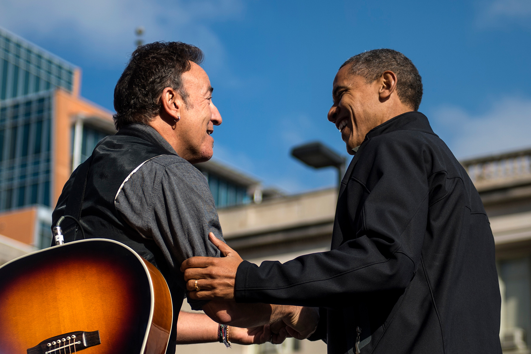 President Barack Obama and musician Bruce Springsteen share a moment, shaking hands, on the campaign trail in 2012
