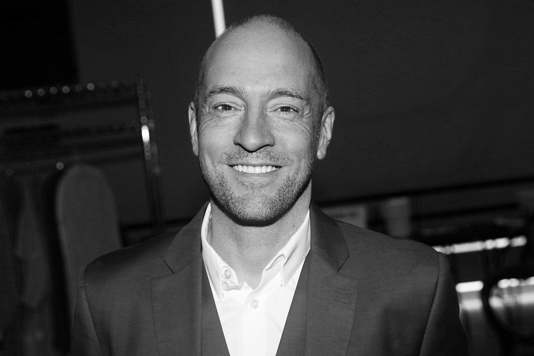 A black and white photo of Derren Brown's head and shoulders.