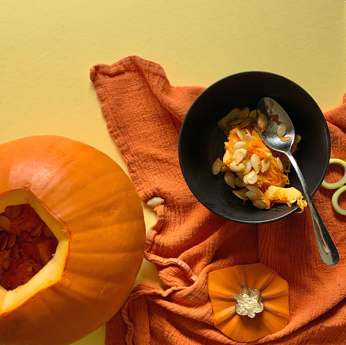 A photo of a pumpkin have it's inner contents scooped out using a spoon