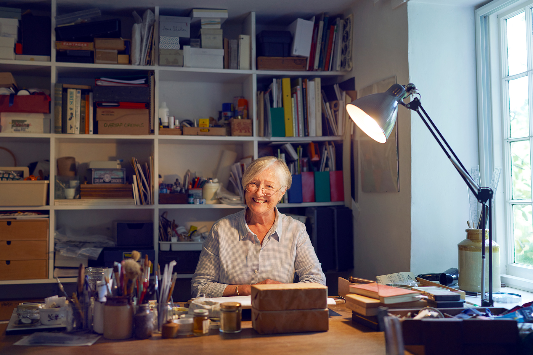 A photograph of Susan Ogilvy at her desk in her studio