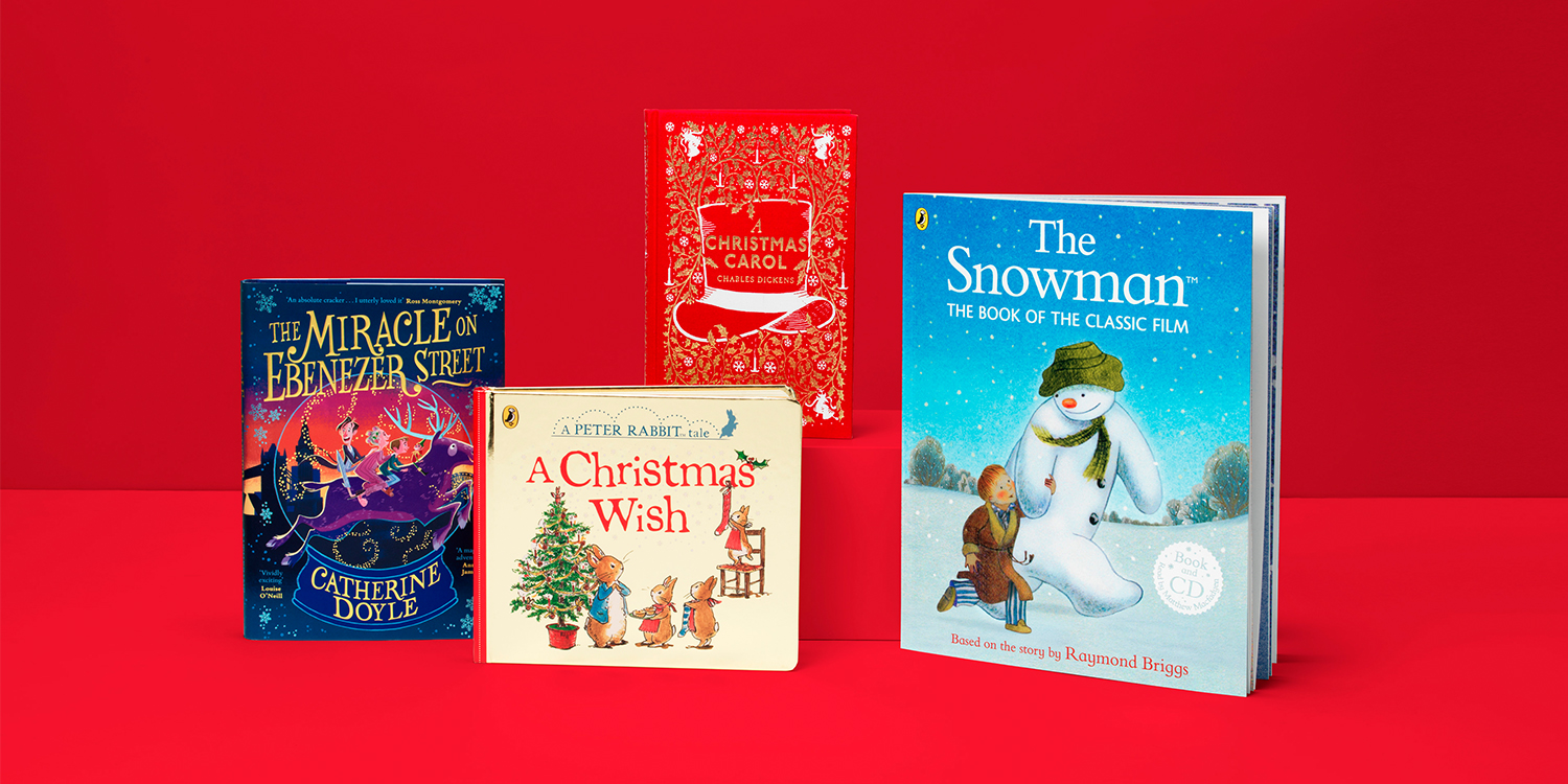 A photo of four Christmas books stacked next to each other on a red background