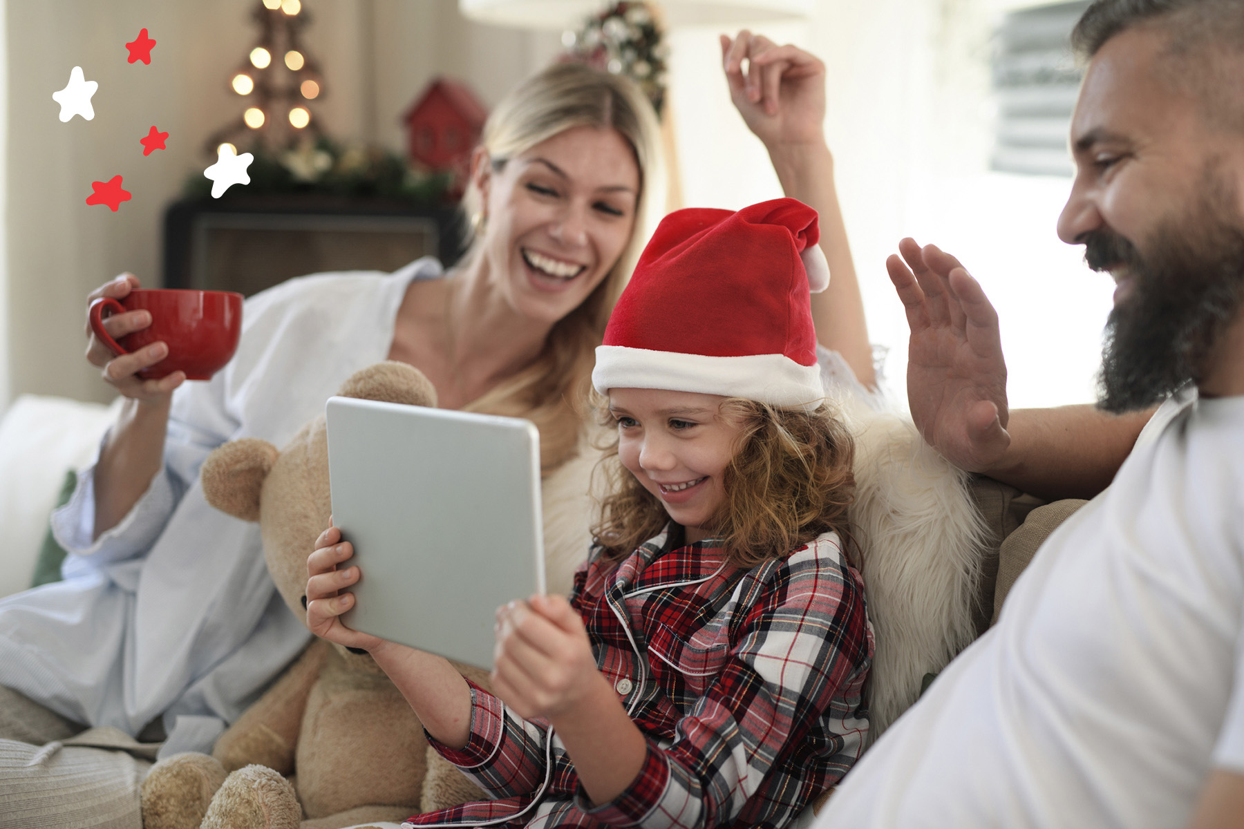 A photo of a young girl and her parents having a video call whilst wearing Christmas hats