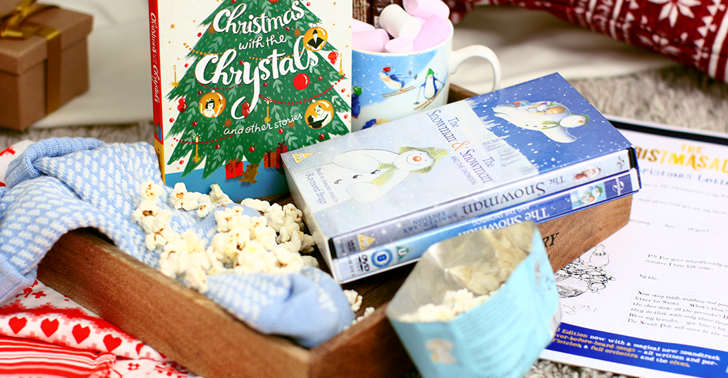 A photo of a Christmas Eve box which includes a copy of The Snowman DVD, Christmas with the Chrystals book, marshmallows, popcorn and a penguin mug