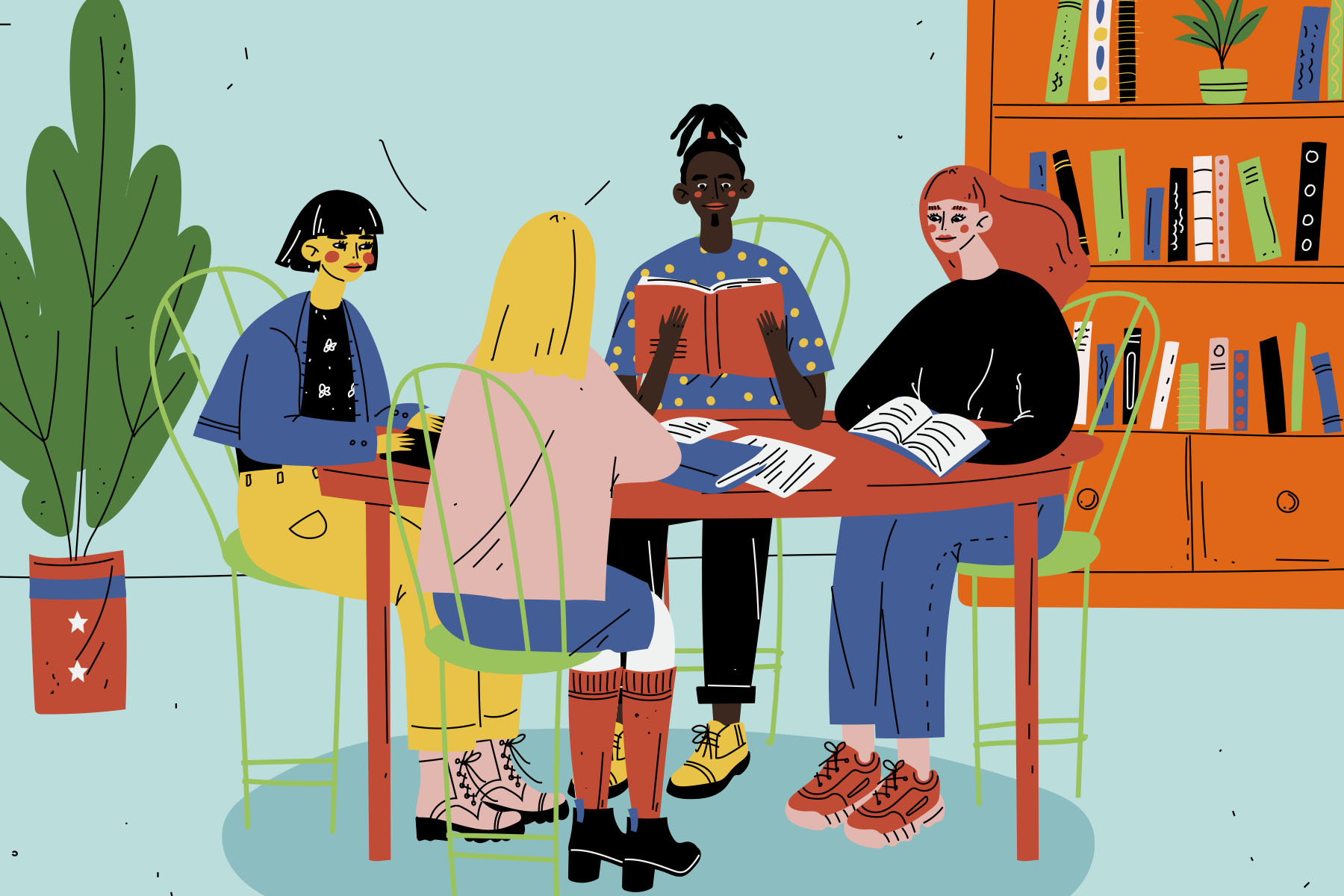 Image of four people sat around a table reading books