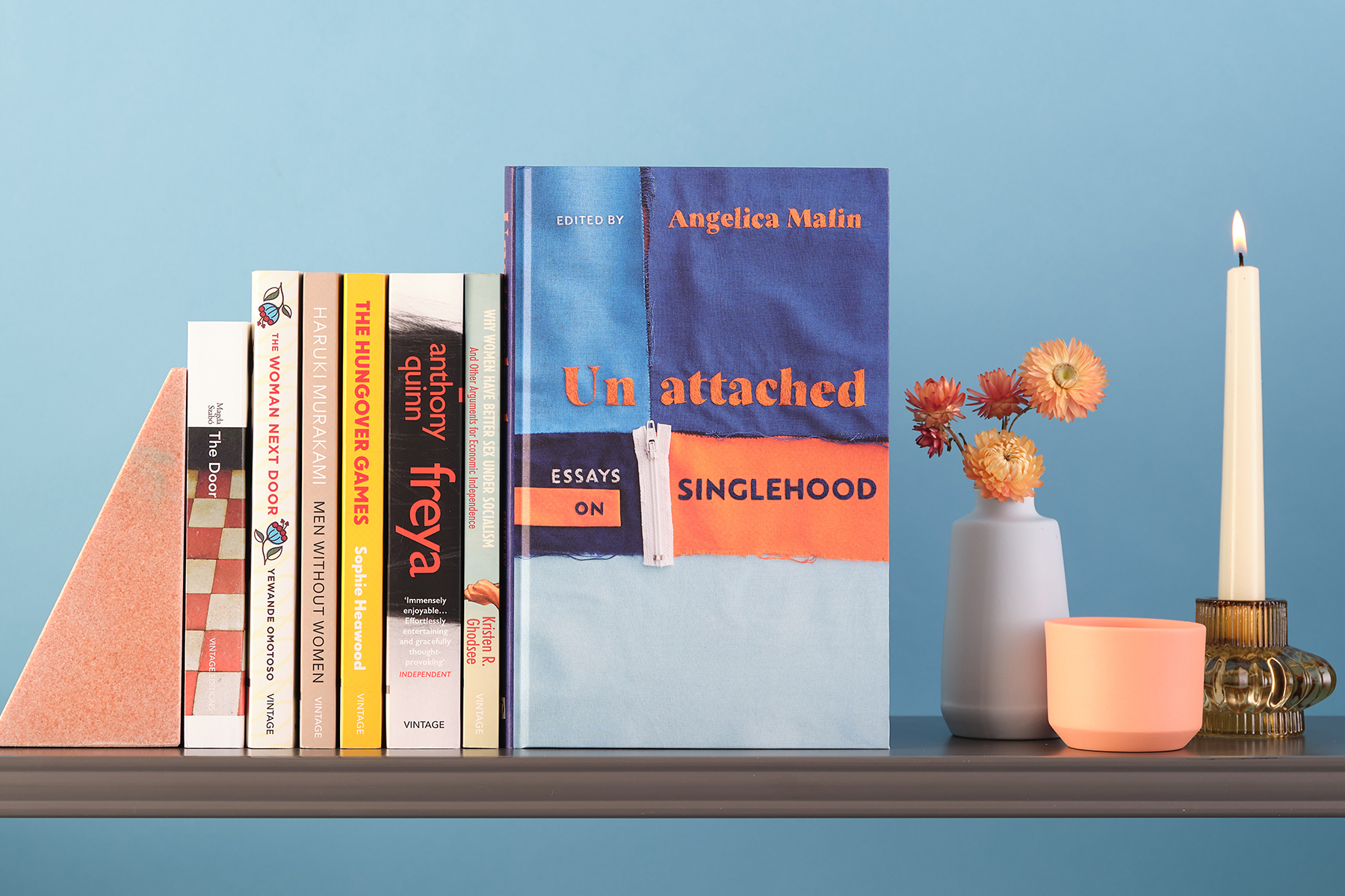 Books on a shelf, showing spines, with Unattached standing upright to one side.