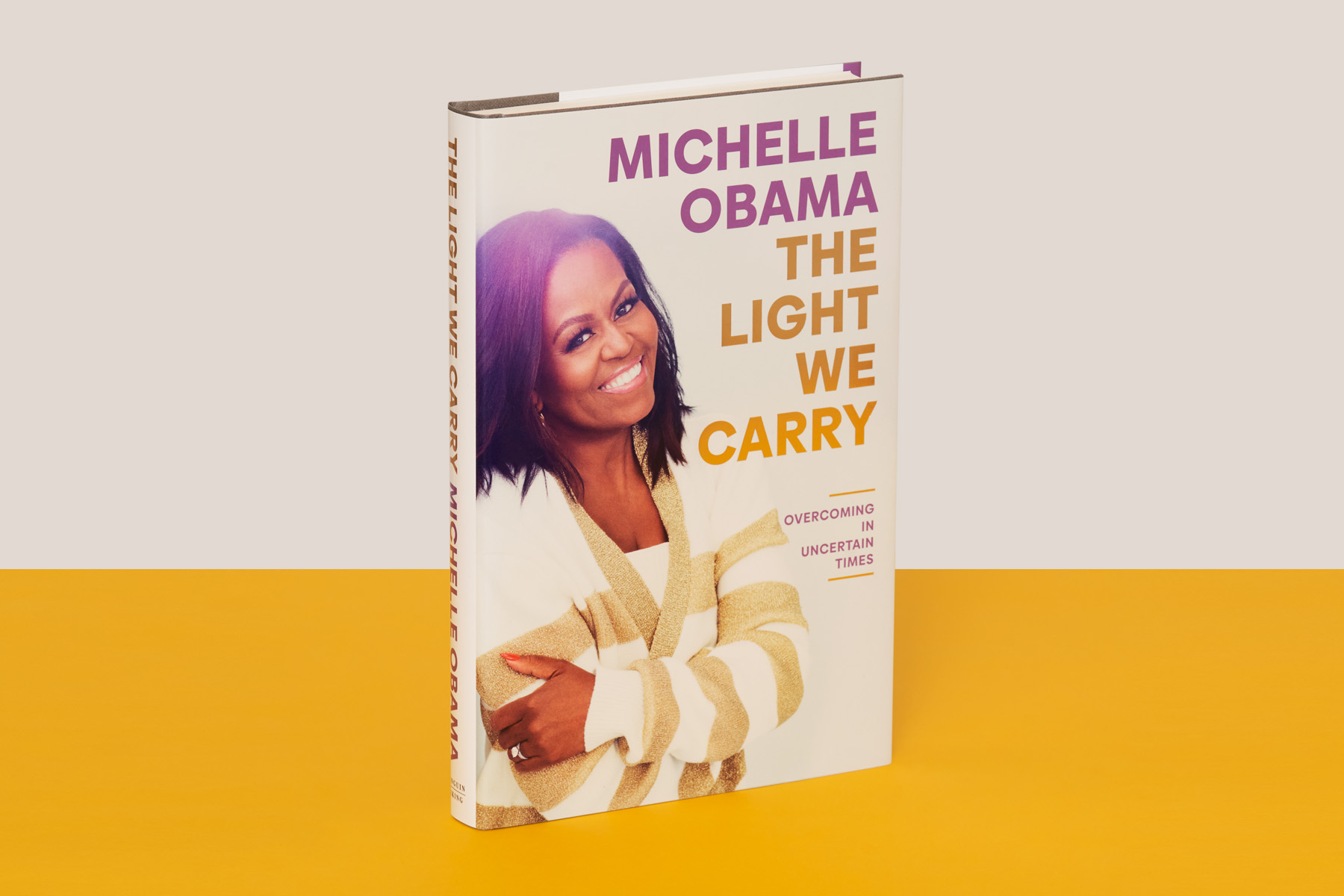 A photograph of Michelle Obama's The Light We Carry on a yellow-and-white background