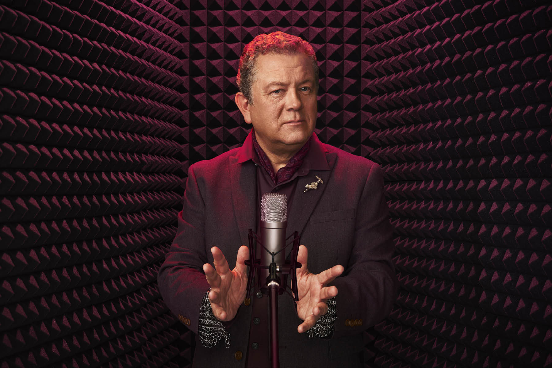 Picture of Jon Culshaw against a black and red lit background