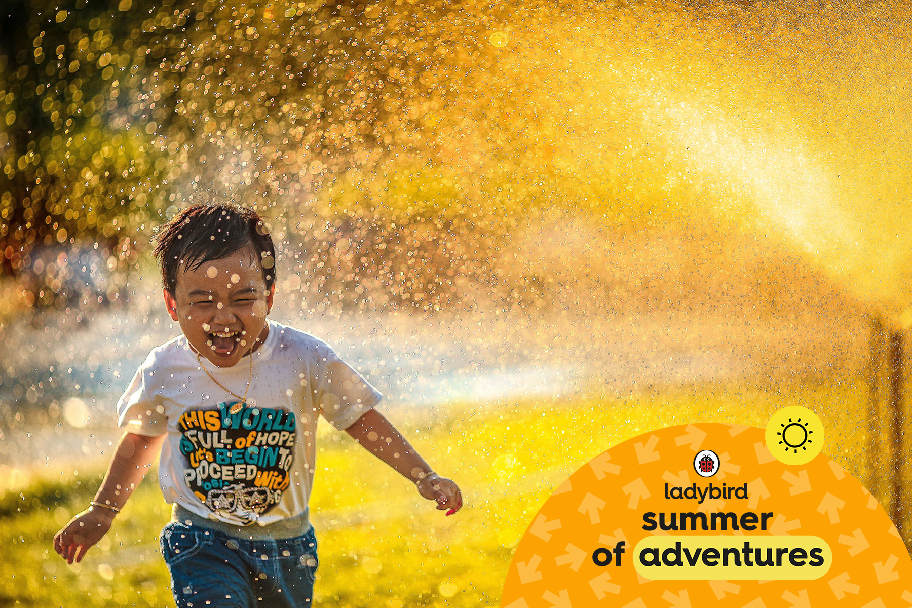 A photo that shows a little boy running away from sprinkler laughing